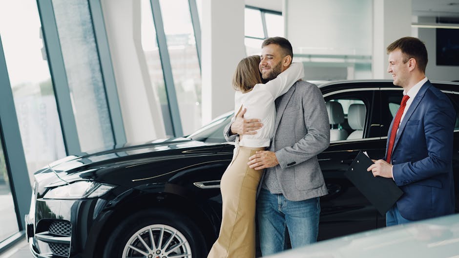 Couple hugging with car salesman after purchasing a new car at a dealership
